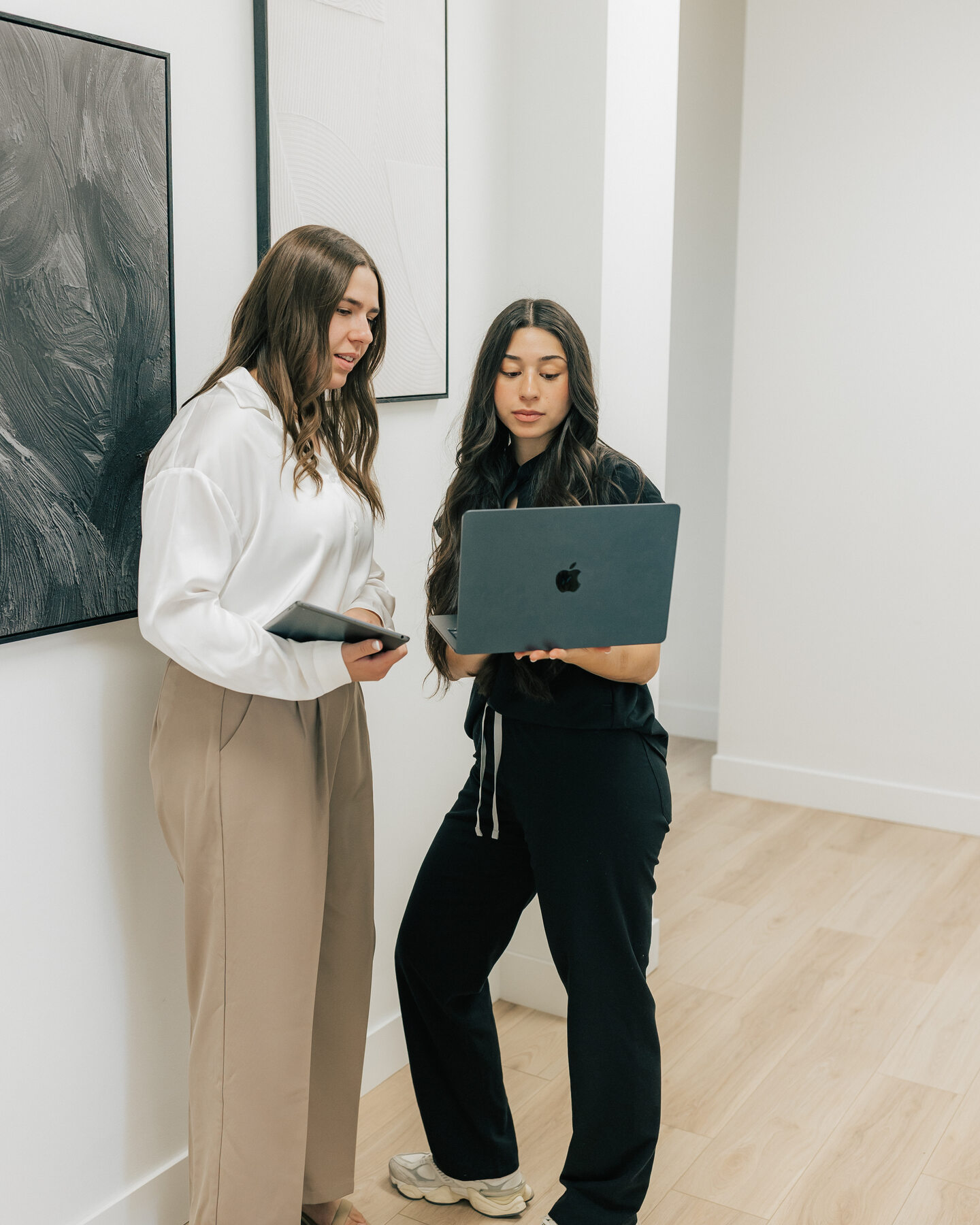Two women review a tablet in a bright clinic room.