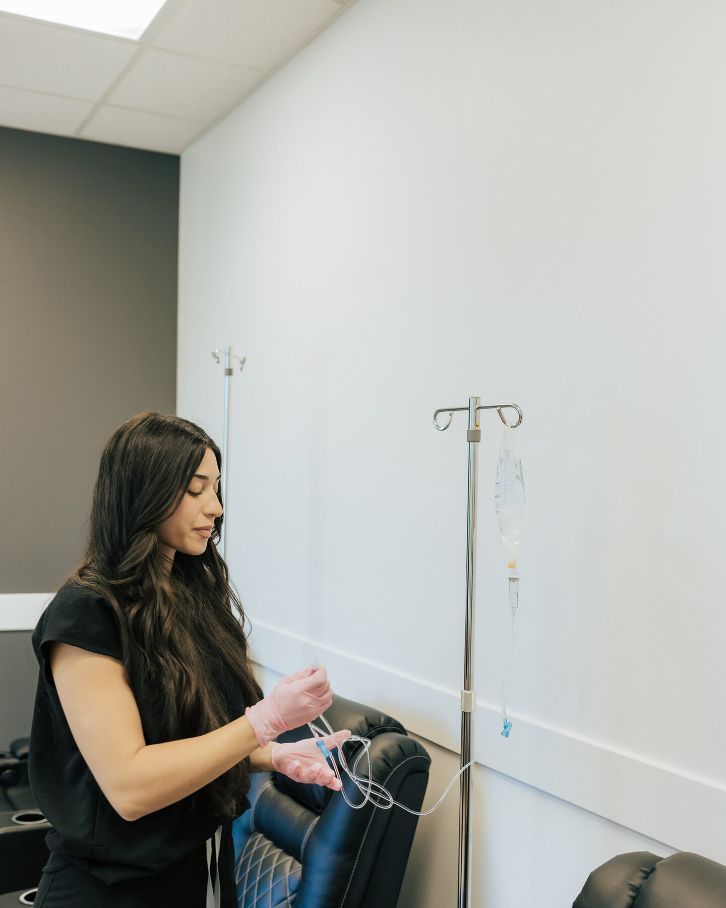 A seated visitor receives care beside an IV stand.